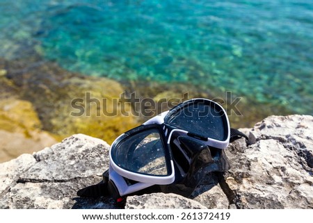 diving goggles on the beach with sea