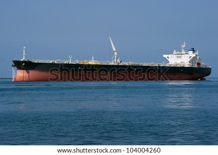 A large chemical tanker ship prepares to leave a harbor