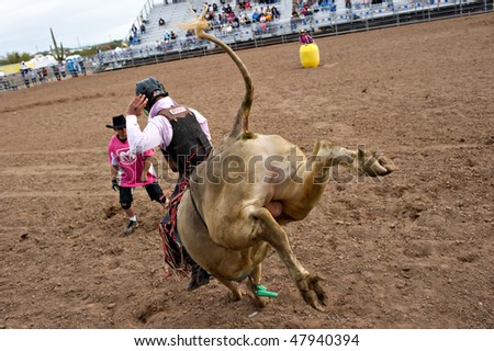 APACHE JUNCTION, AZ - FEBRUARY 26: A cowboy rides a bucking bull in the bull riding competition at the Lost Dutchman Days Rodeo on February 26, 2010 in Apache Junction, Arizona.