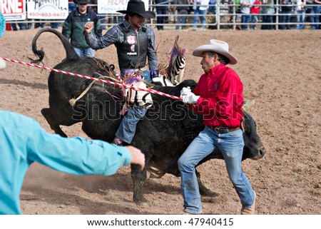 APACHE JUNCTION, AZ - FEBRUARY 27: A rodeo worker gets out of the way of a bucking bull in the bull riding competition at the Lost Dutchman Days Rodeo on February 27, 2010 in Apache Junction, Arizona.