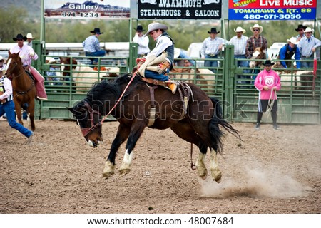 APACHE JUNCTION, AZ - FEBRUARY 26: A cowboy rides a bucking horse in the saddle bronc competition at the Lost Dutchman Days Rodeo on February 26, 2010 in Apache Junction, Arizona.