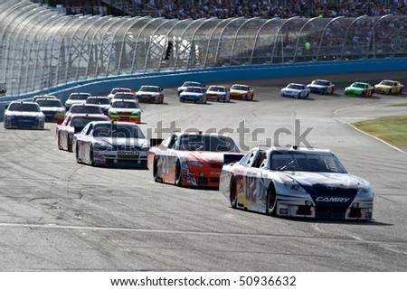 AVONDALE, AZ - APRIL 10: Scott Speed (#82) leads a group of cars out of turn two at the Subway Fresh Fit 600 NASCAR Sprint Cup race on April 10, 2010 in Avondale, AZ.