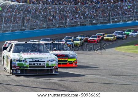 AVONDALE, AZ - APRIL 10: Tony Stewart (#14) leads a group of cars out of turn one at the Subway Fresh Fit 600 NASCAR Sprint Cup race on April 10, 2010 in Avondale, AZ.