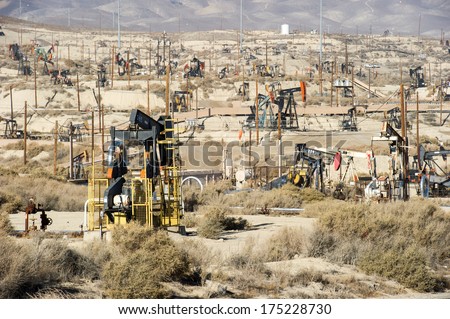 KERN COUNTY, CALIFORNIA - NOVEMBER 26, 2013: Pumpjacks extract oil from an oilfield in Kern County, CA. About 15 billion barrels of oil could be extracted using hydraulic fracturing in California. - stock photo