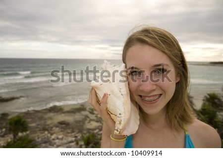 Teenage girl with shell on family holiday in Mexico