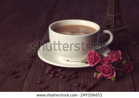 coffee with coffee beans and roses on wooden table