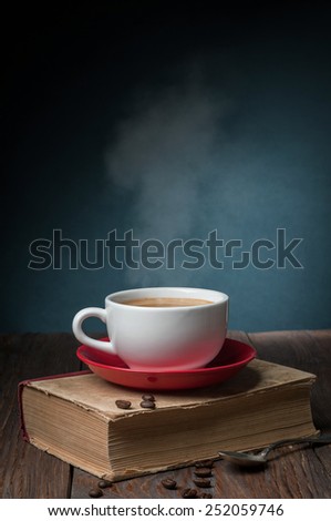 hot coffee on the old book on dark background