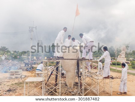 SUPHANBURI, THAILAND - JULY 30 : The casting factory staff pouring molten metal into the buddha mold in the buddha casting ceremony on July 30, 2015 at Wattrivisudhidham temple Suphanburi Thailand.