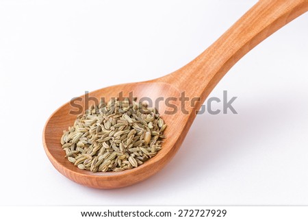 Fennel seeds in a wooden spoon. Spoon diagonally - closeup on fennel