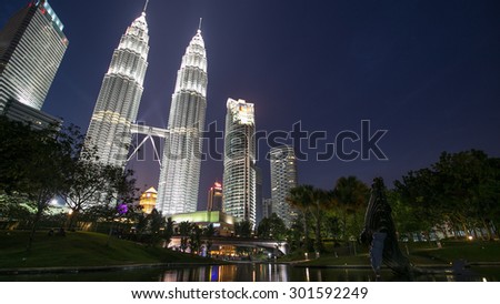 KUALA LUMPUR, MALAYSIA - FEBRUARY, 2014: Water Fountain at Suria KLCC with Petronas Towers and Office Buildings at Blue Hour sunset at Night. It's a popular shopping attraction to locals and tourists.