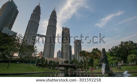 KUALA LUMPUR, MALAYSIA - FEBRUARY, 2014: Water Fountain at Suria KLCC with Petronas Towers and Office Buildings at Blue Hour sunset at Night. It\'s a popular shopping attraction to locals and tourists.