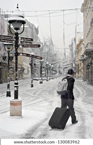 New Year morning. A lone person walking a deserted city street, during heavy snowfall.