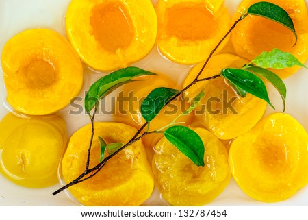 A group of canned peach halves in light syrup.