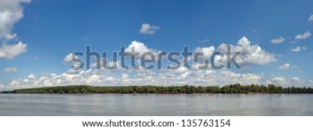 Panoramic image of beautiful blue Danube. Trees are on the other side of the river. Made from several frames stitched together to achieve very high resolution.