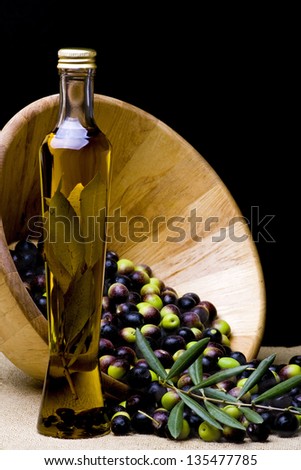bowl and bottle of olive oil with olive branch on burlap background