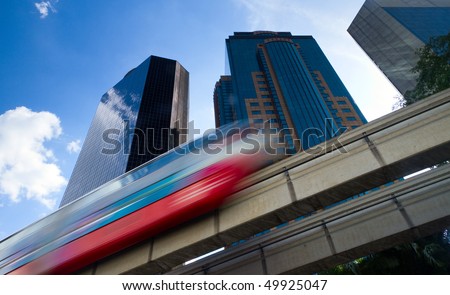 Modern monorail train with office buildings in the background