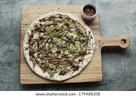 Sweet pizza with Nutella on the wooden board