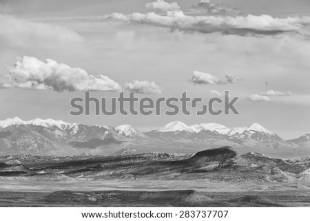 Southwestern landscape with clouds and snow capped mountains in Black and White