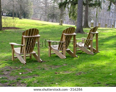 Three lawn chairs in green, green grass.