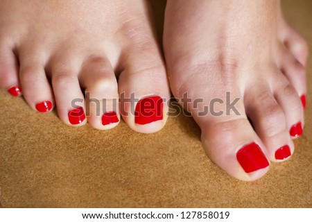 Close-up on pretty sexy women's toes with red nail polish / Female feet with red toenail
