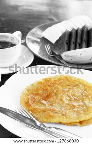 Breakfast in color and black & white / Colored honey pancake with the black and white food background. Focus on the pancake.