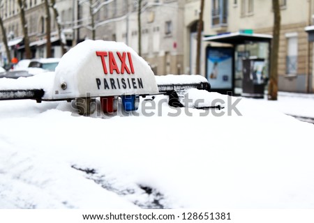 Parisian Taxi under the snow / Rare snow fall in Paris, France - 19th of January 2013. Taxi roof buried under the snow layer