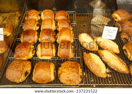 Chocolate bread / Freshly baked French pastries (pain au chocolat, y pain au lait) on griddle for sale in the local Toulouse baker