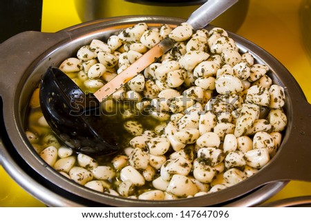 Marinated garlic cloves with herbs and spices in a metal bowl at french farmer\'s market