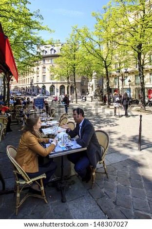 PARIS, FRANCE - APRIL 24 : Woman and man talking over a coffee in the open street cafe at the Sorbonne place on April 24th 2013 in Paris, France