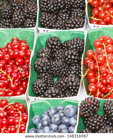 Variety of berries in small individual boxes at french farmer\'s market