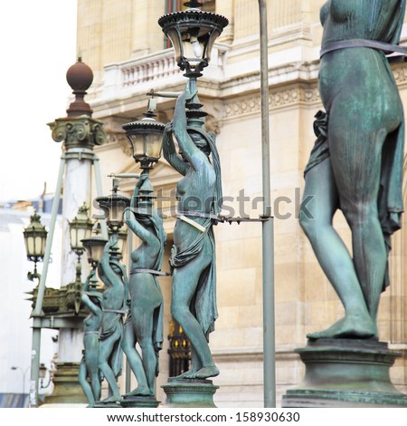 Bronze lampposts shaped as antique caryatides around famous Palais Garnier, the Paris Opera House in Paris, France