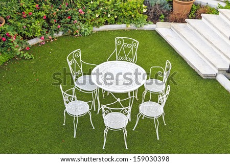 Open summer patio with white wrought iron furniture