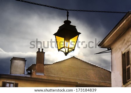 Annecy town\'s lantern - gloomy grey day with a small glimpse of sunshine cought through this yellow lantern.