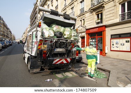 PARIS, FRANCE - MARCH 29 : Garbage truck full of rubbish being loaded by a migrant worker in central Paris, rue Monge on March 29th, 2013 in Paris, France