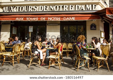 PARIS, FRANCE - APRIL 17 : People chatting over drinks enjoing first spring sun in the cafe \