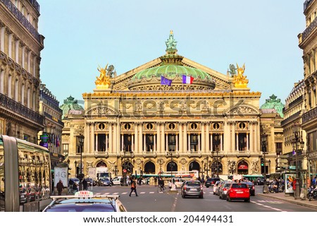 PARIS, FRANCE - FEBRUARY 24 : Front view of the Old Garnier Opera house in Paris with people and cars on the busy street on February 24th, 2014 in Paris, France