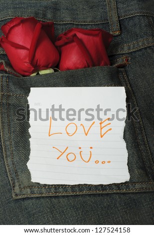 red roses in jeans with paper text love you