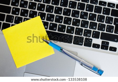 Pen on Scratch paper and the handle lie on the laptop keyboard the keyboard