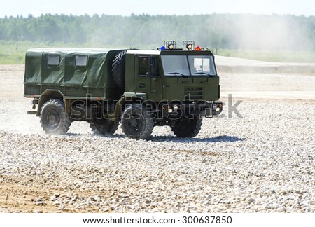 The military vehicle goes on the dusty road