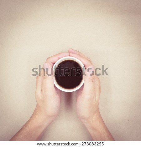 Male hands holding cup coffee with retro filter effect