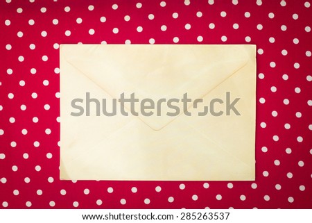 Vintage envelope on red polka dot background with retro filter effect