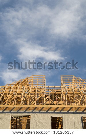 Wood framing construction on a large building with copy space in the blue sky area