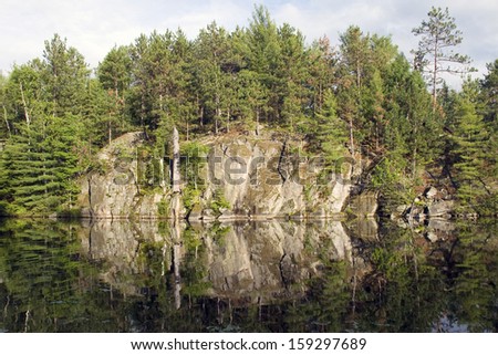 Rock face reflection on a calm evening on a northern lake