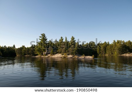 Cottage hidden in the trees on an island in Northern Ontario, with copy space