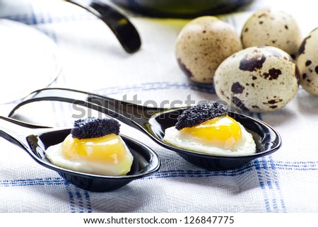 Quail eggs in black spoons