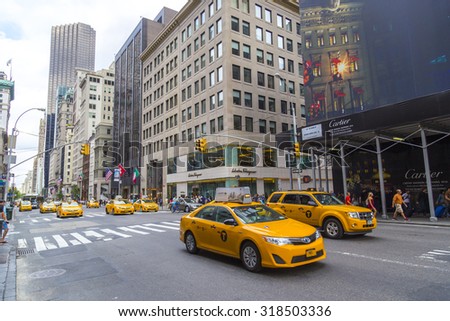 NEW YORK - AUGUST 30, 2014: Yellow taxi cabs ride on 5th Avenue in New York City, USA. 5th Avenue is a central road of Manhattan.