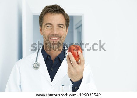 Doctor recommending an apple a day. This photography was made with a professional model and others professionals to reach this quality from a raw.
