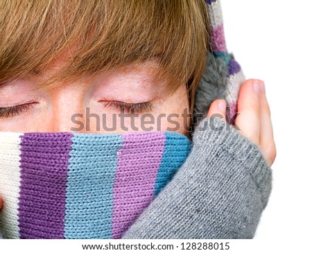 Pretty girl in winter clothes covering her face with warm scarf