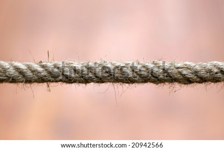 Closeup detail of a rope over a warm background.