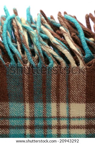 Brown-green checkered tartan wool blanket with fringe isolated on white